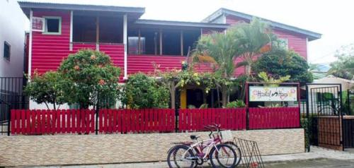 a bike parked in front of a pink house at Hostal Hansi in Bocas del Toro