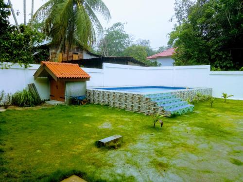 a yard with a swimming pool and a building at Villa Sri Tebengau in Kuah