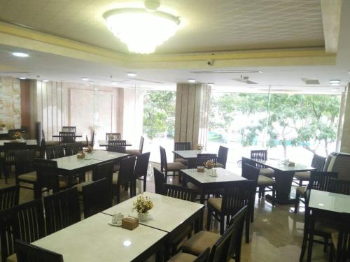 un restaurante con mesas y sillas y una gran ventana en Kay Hotel Da Nang, en Da Nang