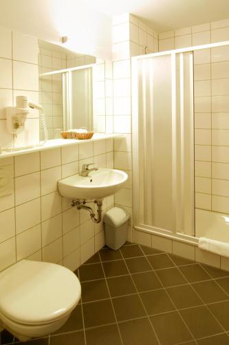 a bathroom with a toilet and a sink and a shower at Familienhotel Citylight in Berlin