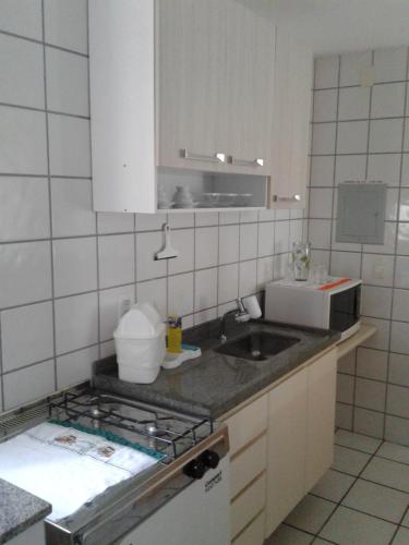a small kitchen with a sink and a microwave at Apart Quartier Latin Hotel in Vitória