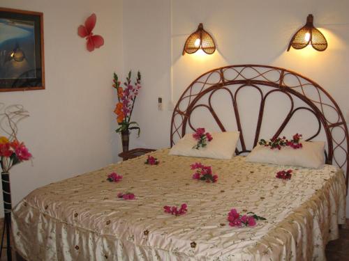 ein Schlafzimmer mit einem großen Bett mit rosa Blumen drauf in der Unterkunft Villa Kissen in Trou aux Biches