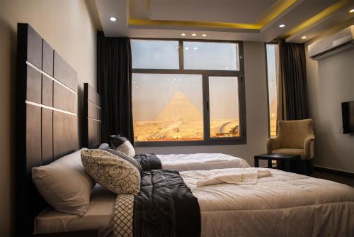 a bedroom with a bed with a view of the pyramids at Marvel Stone Hotel in Cairo