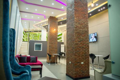 vestíbulo con sofá rojo y pilar de ladrillo en Marvel Stone Hotel, en El Cairo