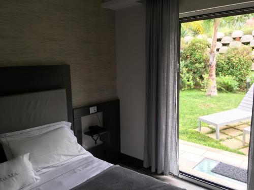 a bedroom with a bed and a large window at Residenza RoMa in Tropea