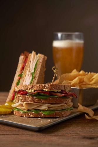 a sandwich on a plate next to a glass of beer at Hyatt Place Chicago O'Hare Airport in Rosemont