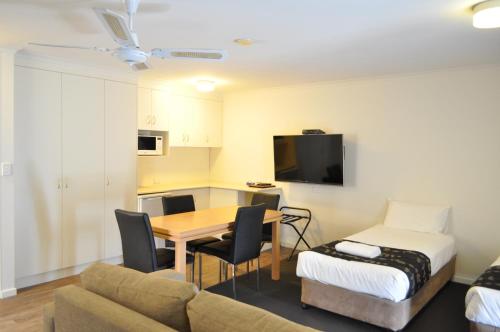 a room with a table and a couch and a bed at Albury Burvale Motor Inn in Albury