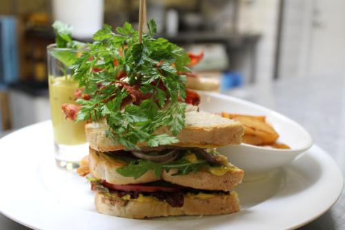 a sandwich on a plate with a bowl of fries at Hotel Aarslev Kro in Brabrand