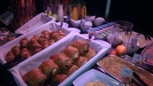 a table topped with trays of pastries and other foods at Campanile Epernay - Dizy 51530 in Épernay