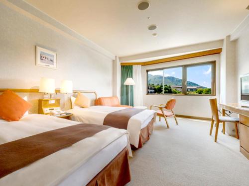 a hotel room with two beds and a window at Hotel Green Plaza Hakone in Hakone