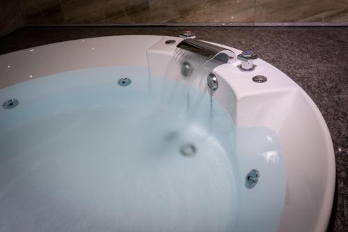 a white bath tub sitting on top of a floor at OUGE Boutique Motel - Pingtung in Jiuru