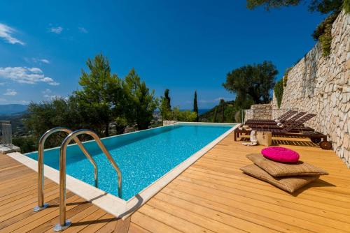 a swimming pool on a wooden deck next to a house at Villa Oliva, in a serene location & private pool, by ZanteWize in Akrotiri