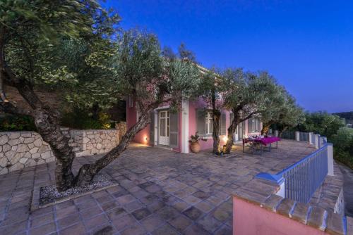 a house with a stone fence and a tree at Villa Oliva, in a serene location & private pool, by ZanteWize in Akrotiri
