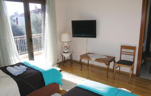 a bedroom with a bed and a tv and a window at Villa Markos in Roitika