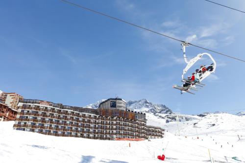 a group of people on a ski lift in the snow at Résidence Odalys Tourotel in Val Thorens