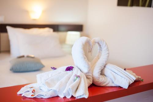two towels shaped like swans sitting on a bed at Al Mare Hotel in Tsilivi