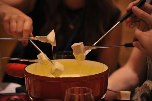 a person pouring food into a pot of food at Guest House du Grand Paradis - On Piste in Champéry