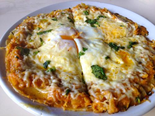 a white plate with a pizza on a table at Tulaja Boutique Hotel in Bhaktapur