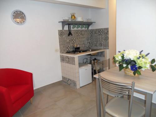 ナポリにあるThat's amoreのキッチン、ダイニングルーム(テーブル、赤い椅子付)