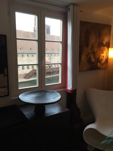 a room with a table in front of a window at Quai 17 Maison d'hôtes in Strasbourg