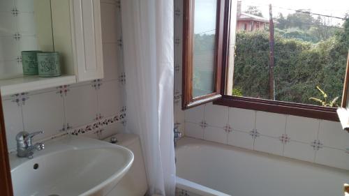 a bathroom with a tub and a sink and a window at Casa Las Vistas Llanes in Nueva de Llanes