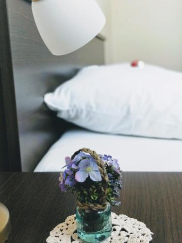 a vase with purple flowers sitting on a table at Apartments Kristina in Klenovica
