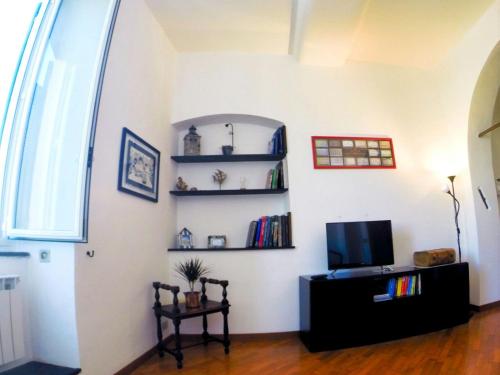uma sala de estar com televisão e prateleiras na parede em La Bitta Sul Molo em Génova