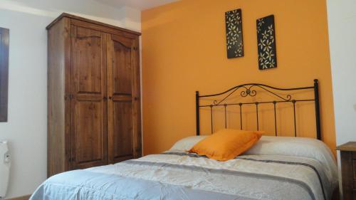 1 dormitorio con 1 cama y armario de madera en Apartamento Casa Farras, en Bonansa