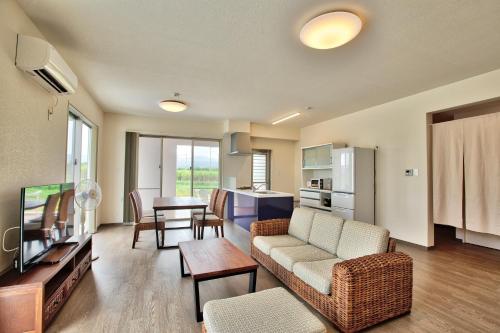 a living room with a couch and a table at Cottage Sea Wind Nakijin in Nakijin