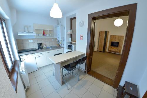 a kitchen with white cabinets and a table and chairs at Apartment Gabriel in Sibiu