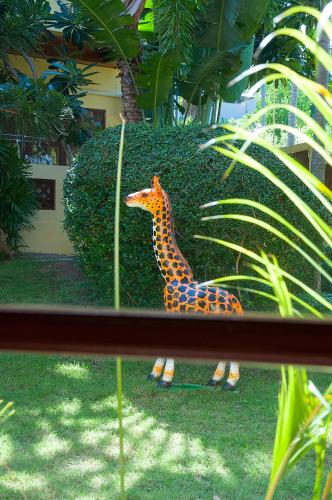 a statue of a giraffe standing in the grass at Samui Green Life in Bophut 