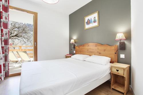 ein Schlafzimmer mit einem großen weißen Bett und einem Fenster in der Unterkunft Résidence Goélia Le Crystal in Vaujany
