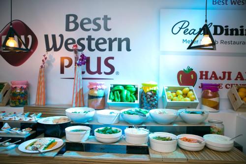 a buffet with bowls of food on a table at Best Western Plus Pearl Creek in Dubai