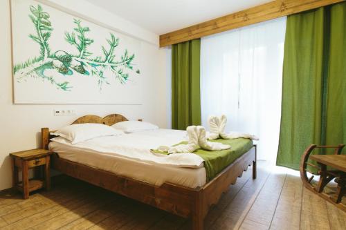 a bedroom with a bed with green curtains at Hotel Superski in Cavnic