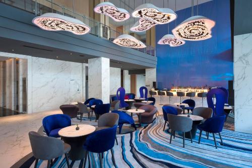 a restaurant with blue chairs and tables in a lobby at Mytt Hotel Pattaya in Pattaya