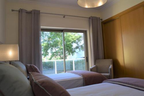 アルブフェイラにあるAlbufeira Marina Goldのベッドルーム1室(ベッド2台、大きな窓付)