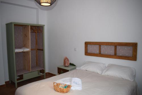 een slaapkamer met een bed met een mand erop bij Hostal Cielo de Gredos in Guisando