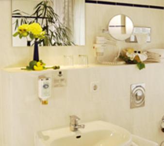 uma casa de banho com um lavatório e um espelho em Andersen Hotel Schwedt em Schwedt