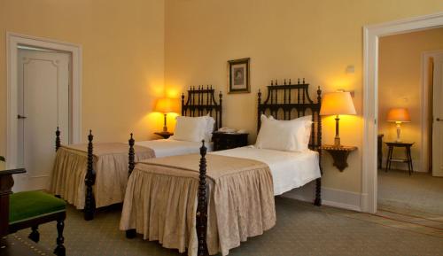 a bedroom with two beds and two lamps at Hotel Avenida Palace in Lisbon
