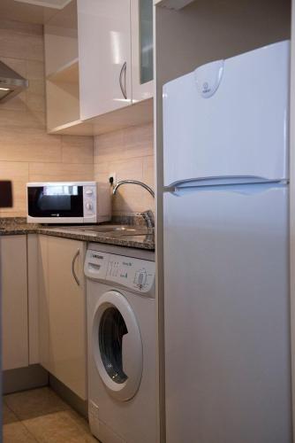a kitchen with a refrigerator and a washing machine at Apartamentos Ripoll Ibiza in Ibiza Town