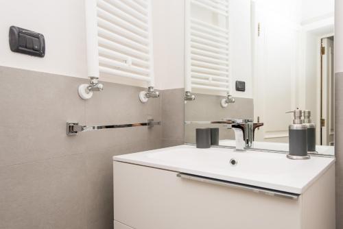 a bathroom with a white sink and a mirror at Il Garbino Suite and Apartment in Lecce