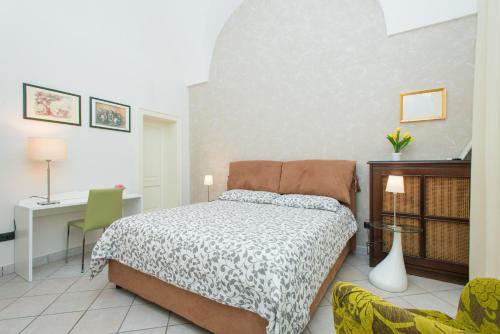 a bedroom with a bed and a desk at Il Garbino Suite and Apartment in Lecce