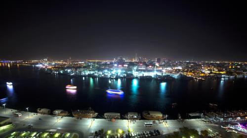 a view of a city at night with boats in the water at Best Western Plus Pearl Creek in Dubai