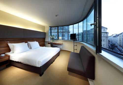 ein Schlafzimmer mit einem Bett und einem großen Fenster in der Unterkunft Eurostars Embassy in Wien