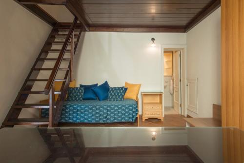 a living room with a blue couch and a staircase at Il Garbino Suite and Apartment in Lecce