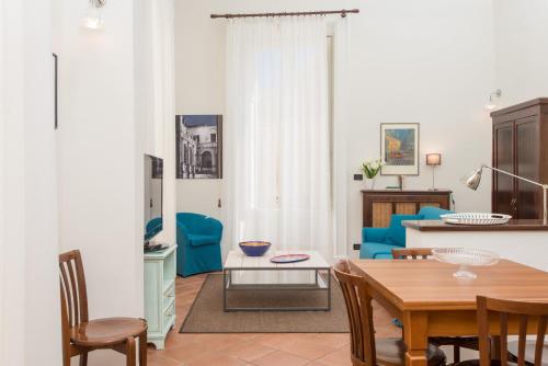 uma sala de estar com uma mesa e um sofá azul em Il Garbino Suite and Apartment em Lecce