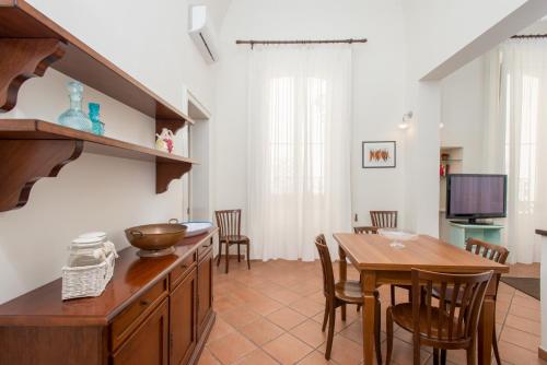 a kitchen and dining room with a table and chairs at Il Garbino Suite and Apartment in Lecce