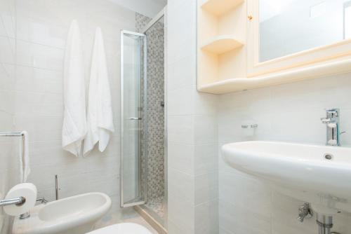 a white bathroom with a sink and a toilet at Il Garbino Suite and Apartment in Lecce