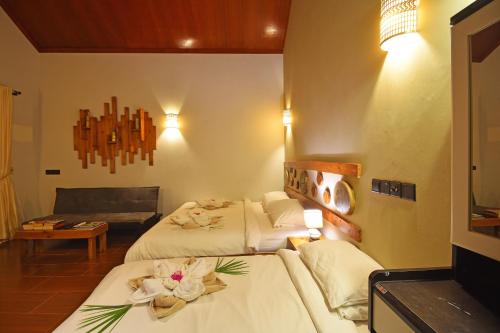 a hotel room with two beds and a couch at Beach Villa Ukulhas in Ukulhas