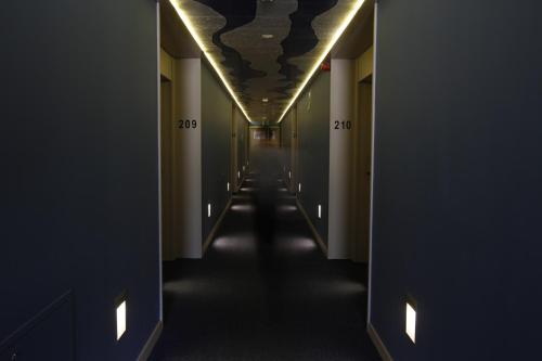a long hallway with a dark corridor at Hotel Spa Aguas de los Mallos in Murillo de Gállego